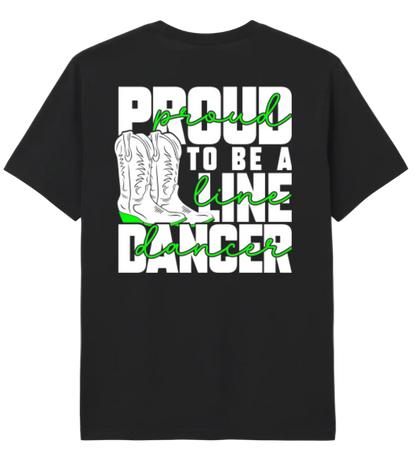 A black short-sleeve t-shirt with a graphic print on the front. The graphic features the text 'PROUD TO BE A LINE DANCER' in white and bright green script, alongside an illustration of a white cowboy boot.